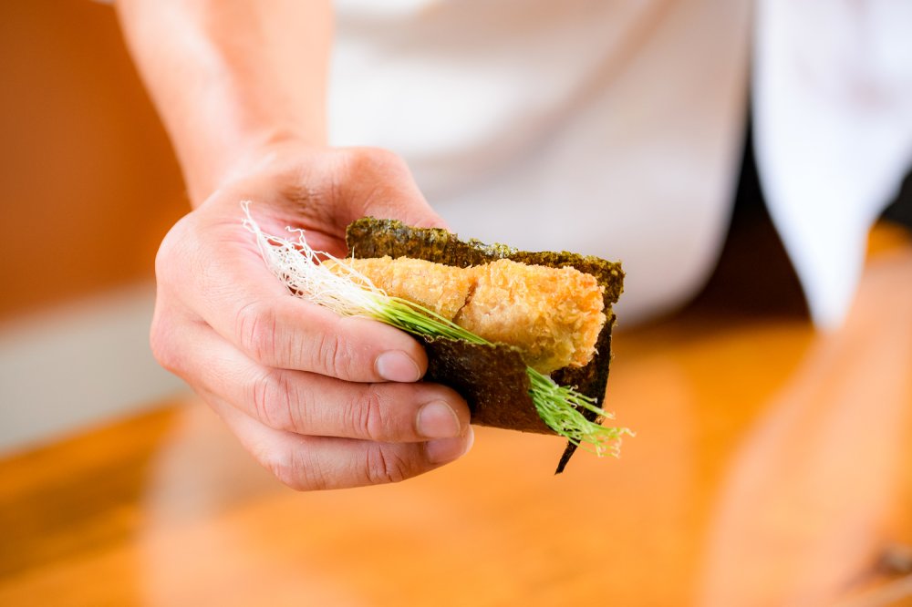 常陸の輝きを揚げてカツ状にしたお寿司。糸状の小ねぎの風味と酢飯、カツのサクサク感の相乗効果でおいしさが広がる。